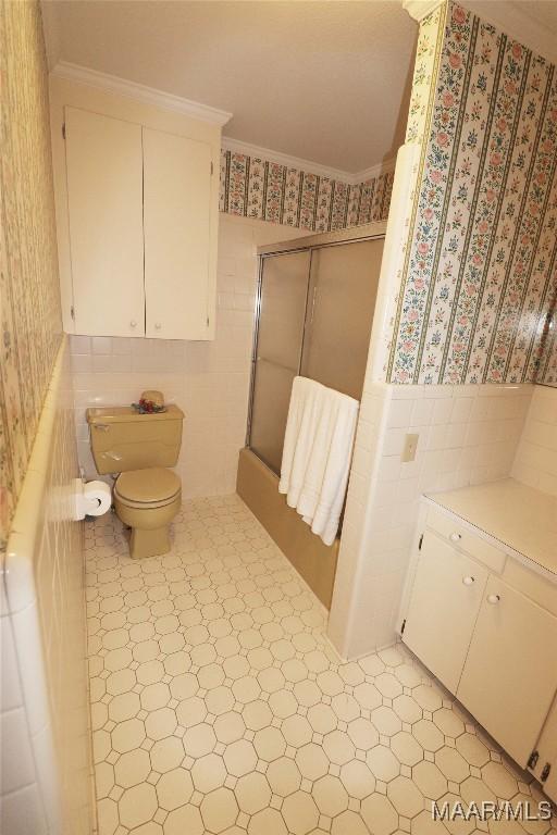 full bathroom featuring tile walls, a wainscoted wall, toilet, and tile patterned floors