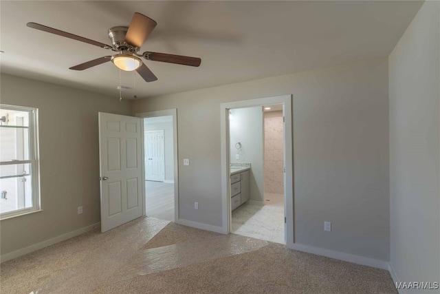 unfurnished bedroom with ensuite bath, baseboards, ceiling fan, and light colored carpet