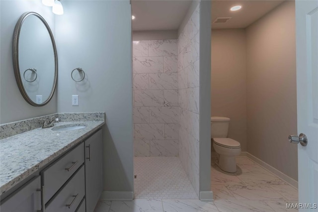 bathroom featuring toilet, marble finish floor, vanity, and baseboards