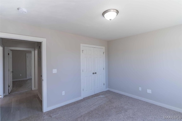 unfurnished bedroom featuring carpet floors, a closet, and baseboards