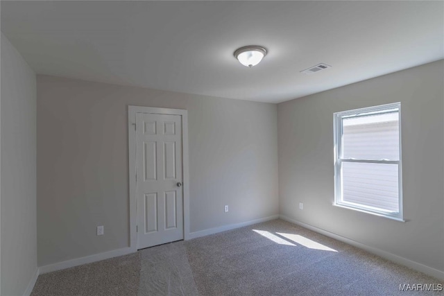 unfurnished room featuring carpet floors, visible vents, and baseboards