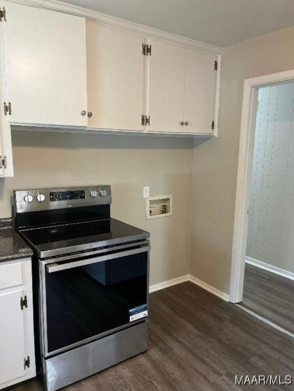 kitchen with dark hardwood / wood-style floors, white cabinetry, dark stone counters, and electric stove