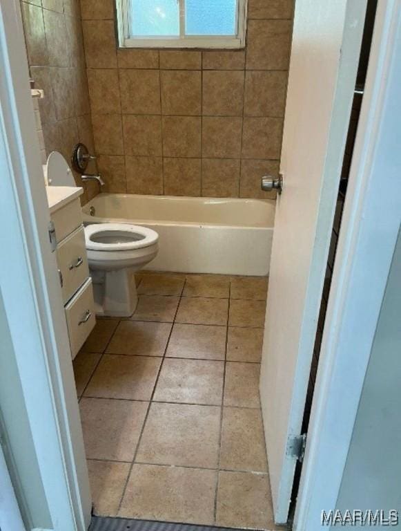 full bathroom with tile patterned floors, vanity, toilet, and tiled shower / bath combo