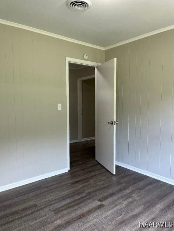 spare room featuring dark wood-type flooring and ornamental molding