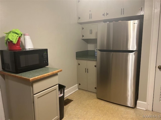 kitchen featuring white cabinets and stainless steel fridge