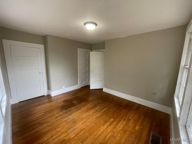 unfurnished bedroom featuring dark hardwood / wood-style flooring