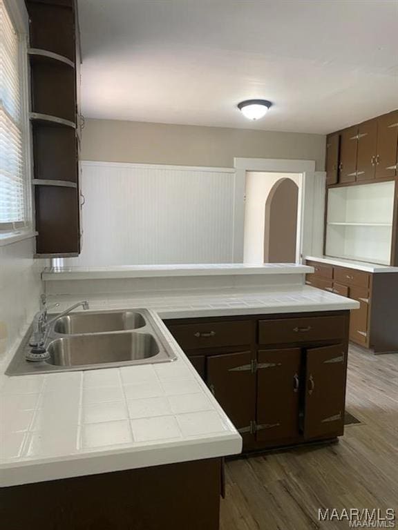 kitchen with dark brown cabinetry, sink, and dark hardwood / wood-style flooring