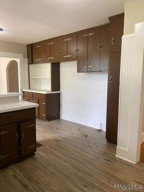 kitchen with dark brown cabinetry and dark hardwood / wood-style floors