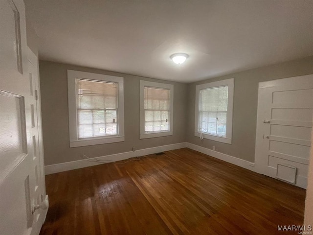 empty room with dark hardwood / wood-style floors