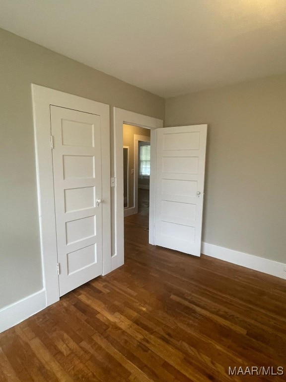 spare room with dark wood-type flooring