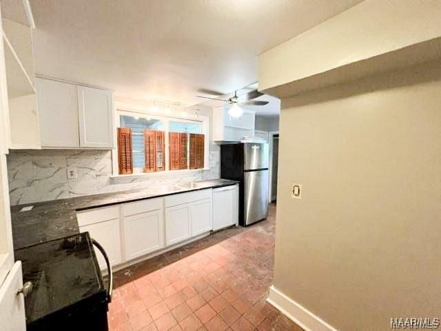 kitchen featuring backsplash, stainless steel refrigerator, white cabinetry, and ceiling fan