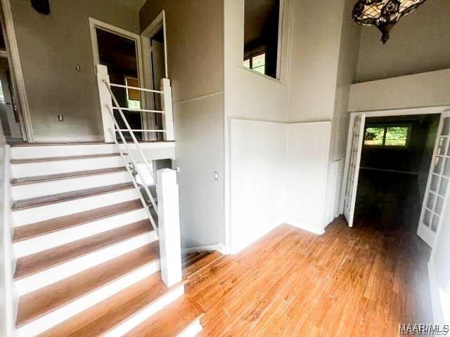 staircase with hardwood / wood-style floors and a high ceiling