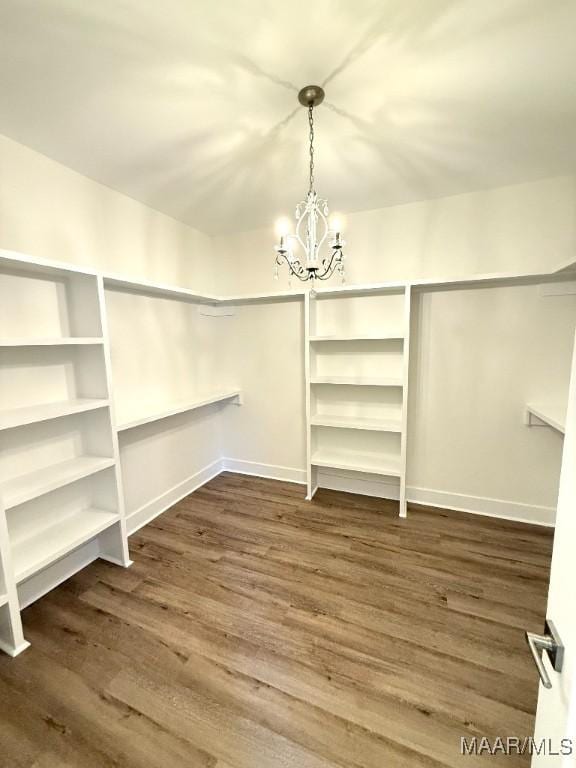 spacious closet with a chandelier and wood finished floors