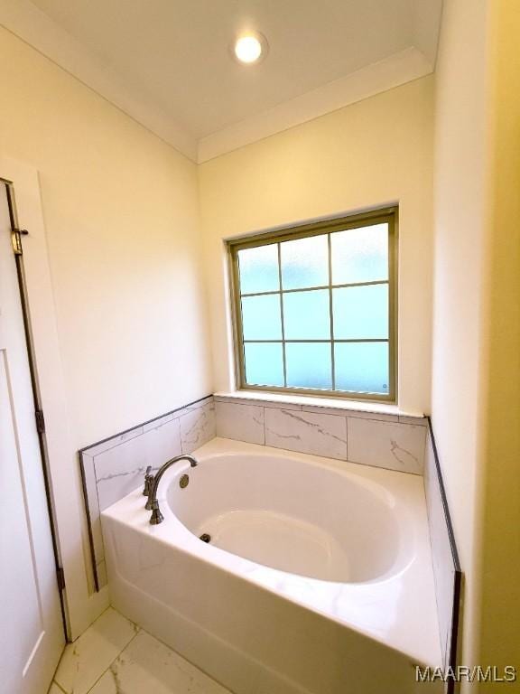 bathroom with a garden tub, marble finish floor, and crown molding