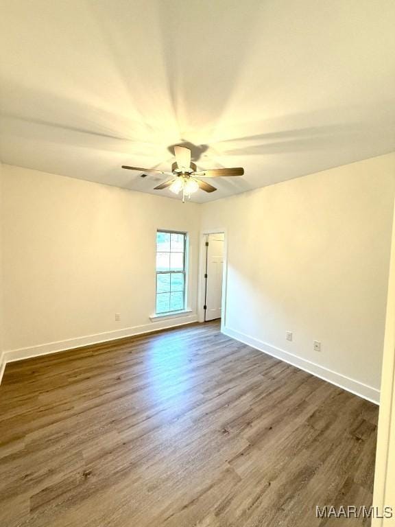 empty room with ceiling fan, baseboards, and wood finished floors