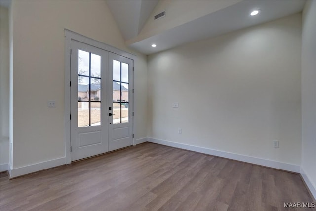 entryway with light wood-type flooring, lofted ceiling, and french doors