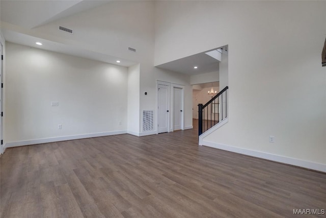 interior space featuring hardwood / wood-style flooring, high vaulted ceiling, and an inviting chandelier