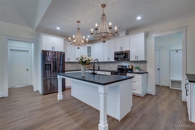 kitchen with a kitchen island with sink, white cabinetry, and stainless steel appliances