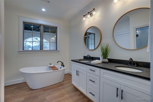 bathroom featuring a bath, vanity, and wood-type flooring