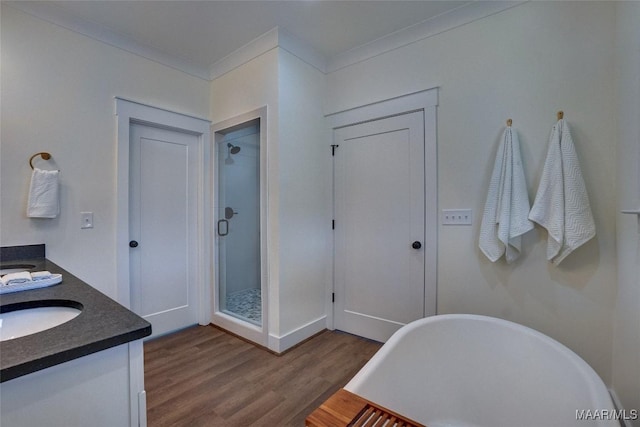 bathroom with vanity, crown molding, wood-type flooring, and shower with separate bathtub