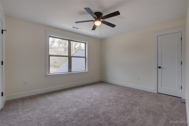 spare room with ceiling fan and light colored carpet