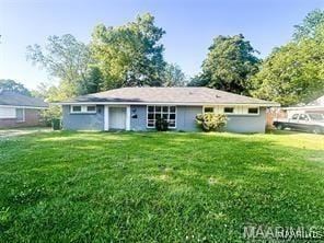 rear view of property with a lawn