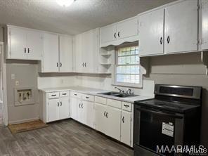 kitchen with black / electric stove, sink, and white cabinets