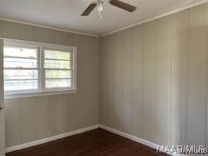 unfurnished room featuring ceiling fan, ornamental molding, and dark wood-type flooring