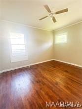 spare room featuring dark wood-type flooring, ceiling fan, and ornamental molding