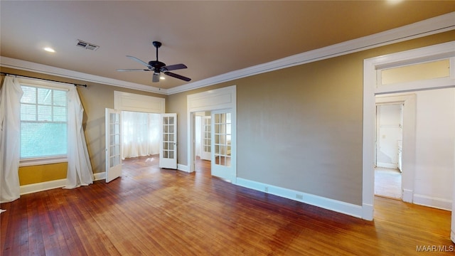 empty room with hardwood / wood-style floors, ceiling fan, ornamental molding, and french doors