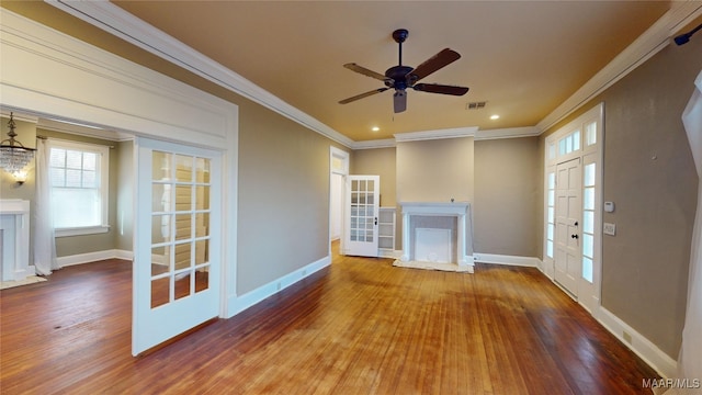 unfurnished living room featuring a fireplace, wood-type flooring, ornamental molding, ceiling fan, and french doors