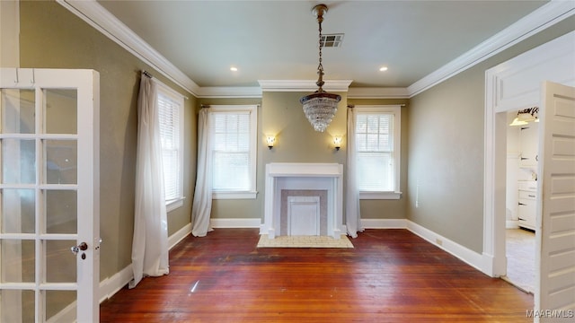 unfurnished living room with a healthy amount of sunlight, crown molding, and dark wood-type flooring