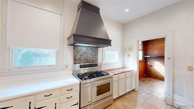 kitchen featuring double oven range, custom range hood, and white cabinets