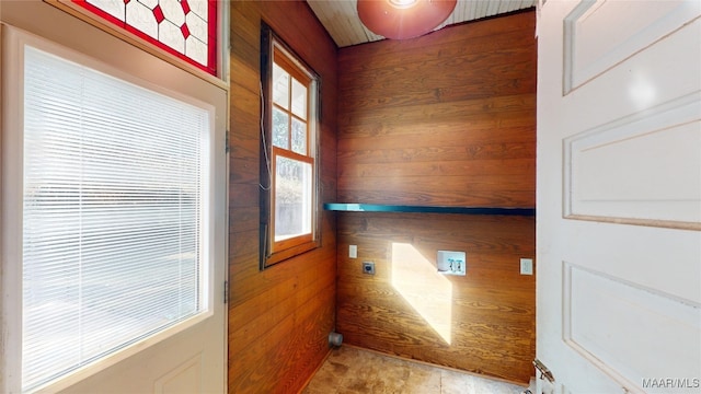 clothes washing area featuring hookup for a washing machine, hookup for an electric dryer, and wood walls