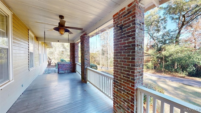 wooden terrace with ceiling fan and covered porch