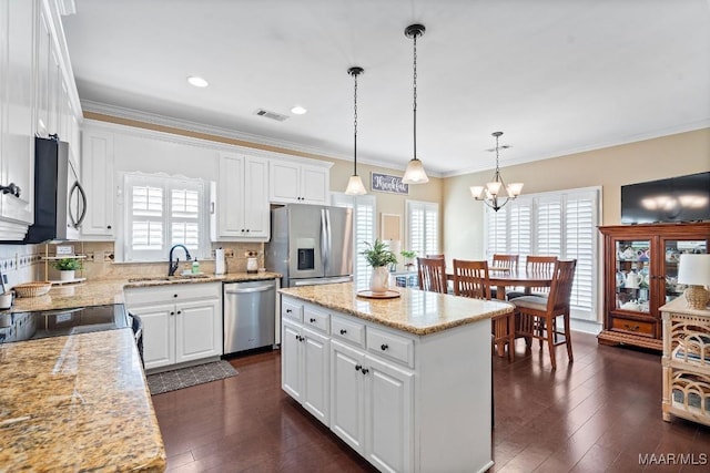 kitchen with white cabinetry, a center island, sink, decorative light fixtures, and appliances with stainless steel finishes