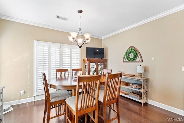 dining area featuring dark hardwood / wood-style flooring, an inviting chandelier, and ornamental molding