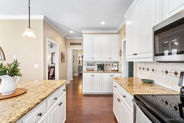 kitchen with white cabinets, decorative light fixtures, stainless steel appliances, and tasteful backsplash