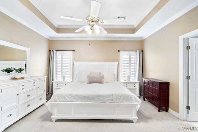 bedroom featuring a tray ceiling, ceiling fan, crown molding, and light carpet