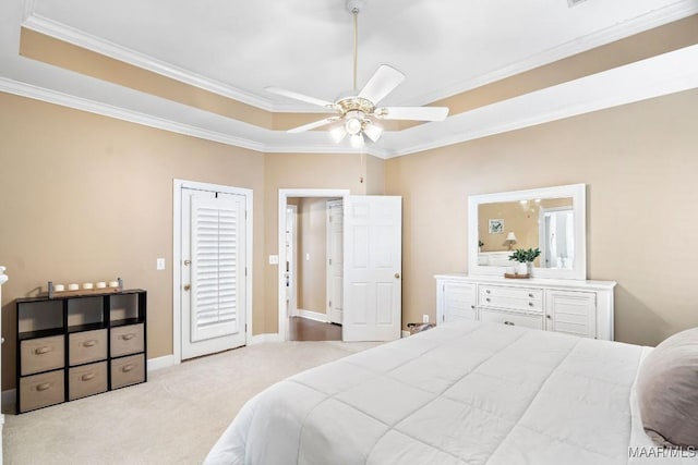 carpeted bedroom with a raised ceiling, ceiling fan, and ornamental molding