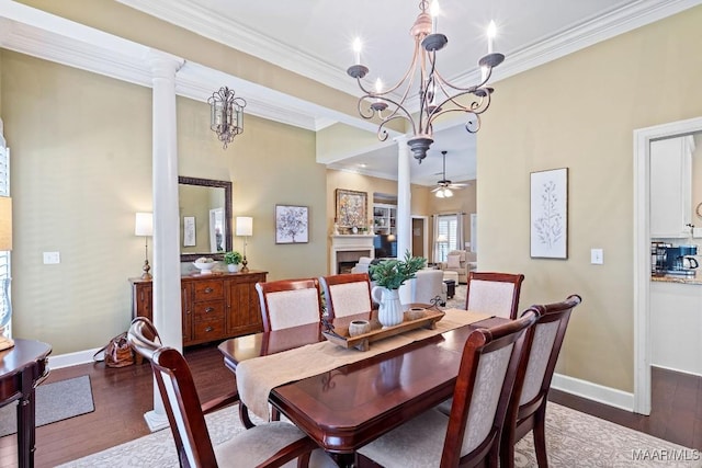 dining room featuring ceiling fan with notable chandelier, dark hardwood / wood-style flooring, ornate columns, and ornamental molding