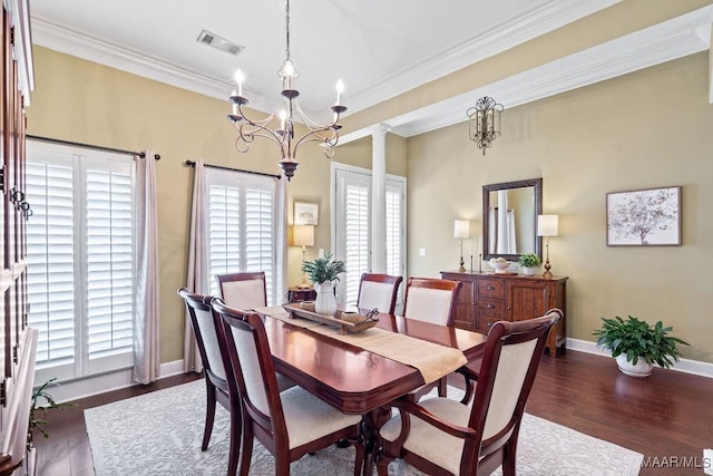 dining room with an inviting chandelier, dark hardwood / wood-style floors, ornate columns, and ornamental molding