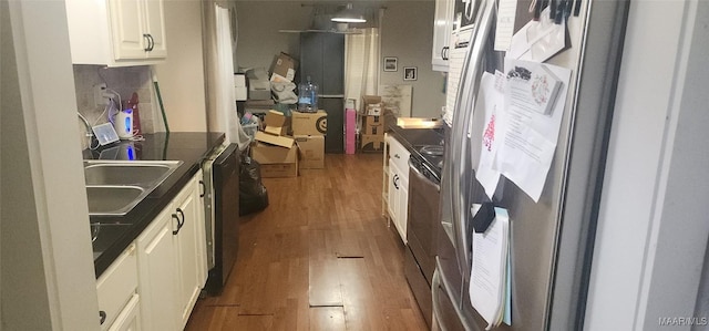 kitchen with dark hardwood / wood-style floors, stainless steel fridge, white cabinetry, and sink