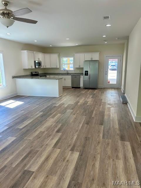 kitchen featuring kitchen peninsula, ceiling fan, white cabinets, and stainless steel appliances