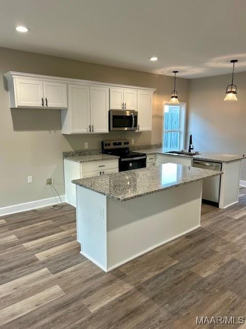 kitchen featuring white cabinetry, pendant lighting, a center island, and stainless steel appliances