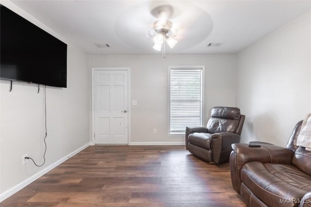 living area featuring ceiling fan and dark hardwood / wood-style flooring