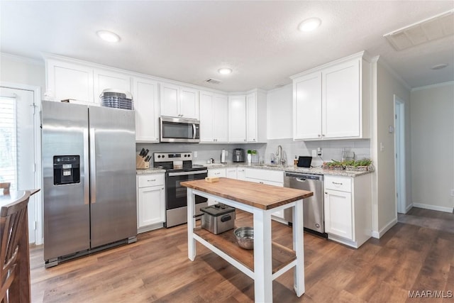 kitchen featuring dark hardwood / wood-style flooring, white cabinets, and appliances with stainless steel finishes