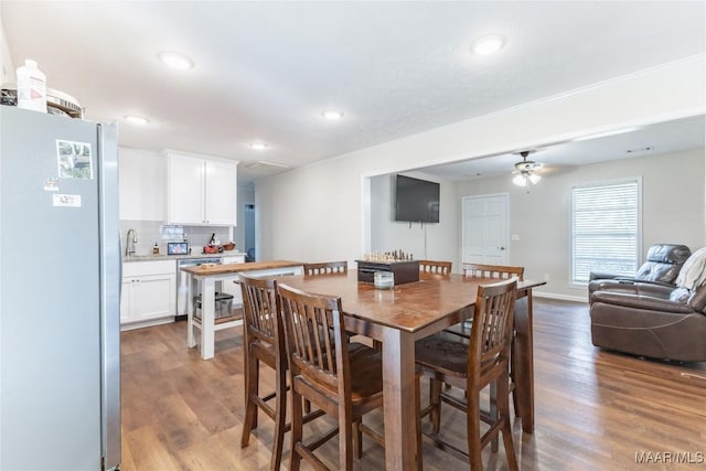 dining room featuring ceiling fan, sink, and hardwood / wood-style flooring