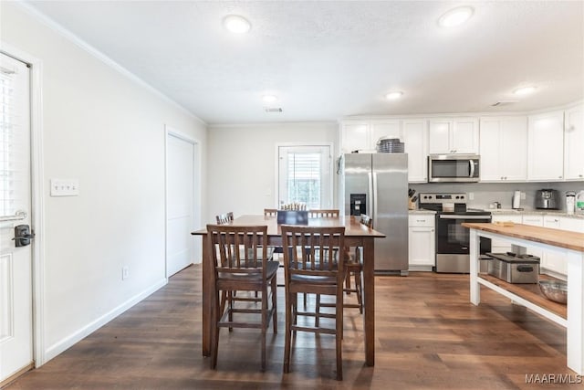 dining area featuring ornamental molding and dark wood-type flooring