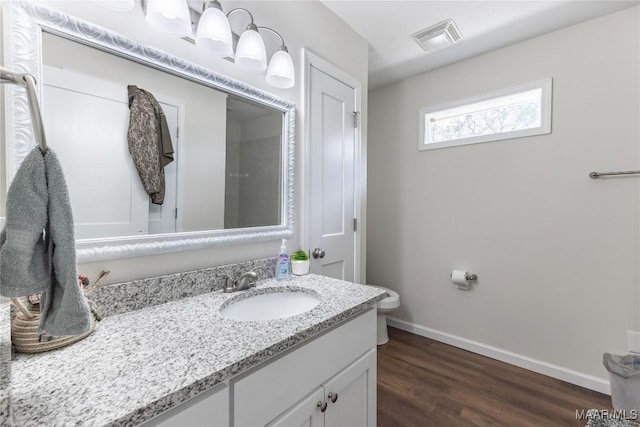 bathroom featuring vanity, wood-type flooring, and toilet